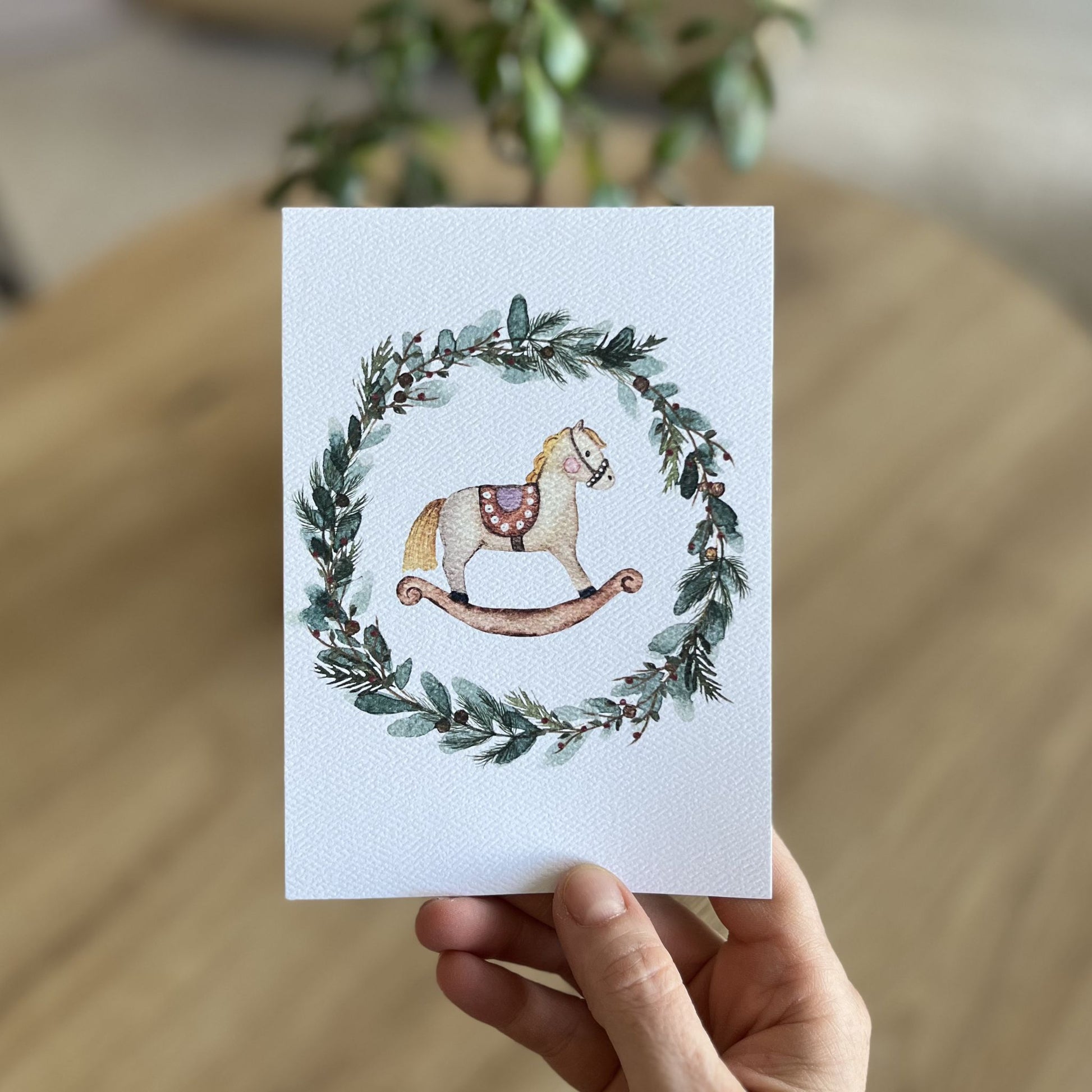 Grußkarte Schaukelpferd im Blätterkranz von Christinas Kartenkunst