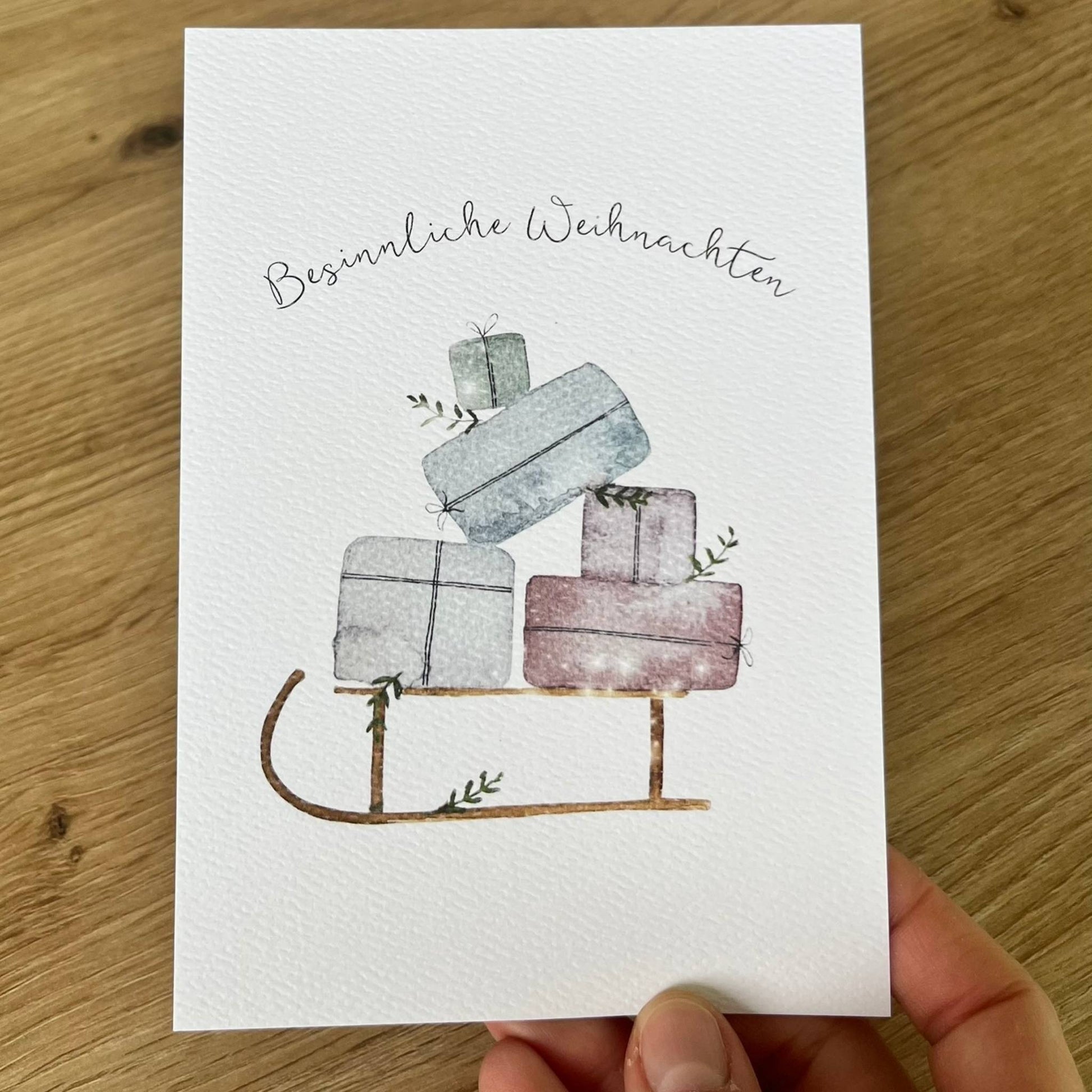 Weihnachtskarte "Besinnliche Weihnachten" mit Holzschlitten-Motiv und Weihnachtsgeschenken Christinas Kartenkunst